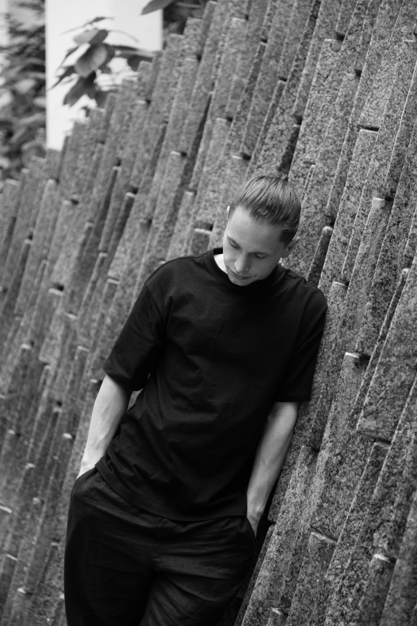 Nikita Kissel leaning against a ribbed stone wall